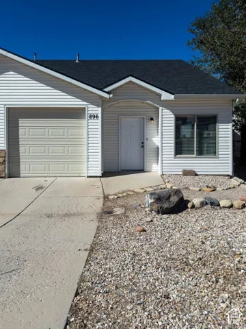 Exterior featuring horizontal vinyl siding, asphalt shingle roof, attached single-car garage, concrete driveway, and rock-based landscaping