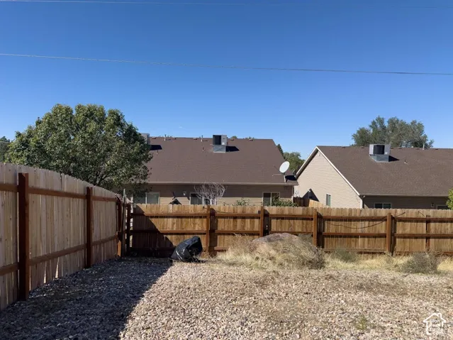 Backyard featuring a wood-panel perimeter fence and stone ground cover
