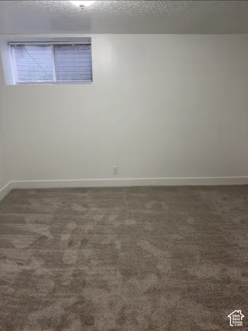 Neutral-toned wall-to-wall carpeting, crisp white walls, and a recessed window with horizontal blinds