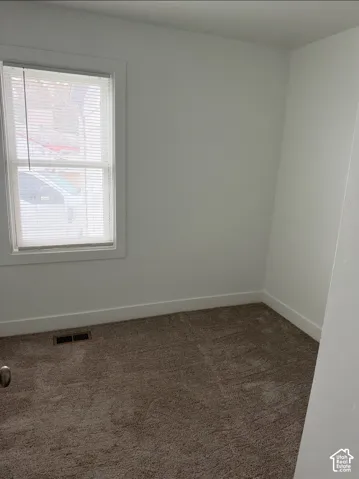 Neutral-toned carpeting, crisp white wall finishes, and a single-pane window with white casing