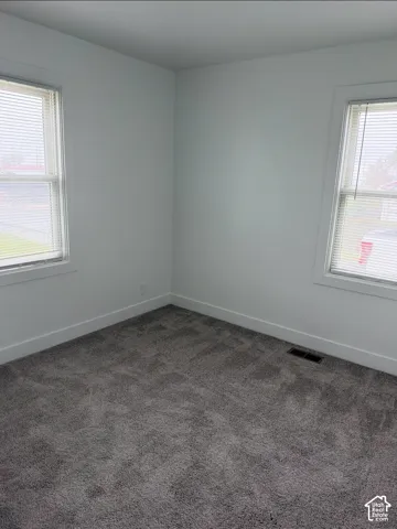 Neutral wall-to-wall carpeting, dual windows, and crisp white wall finish