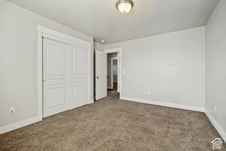 Neutral wall tones featuring carpeting, recessed panel closet doors, and a flush-mount light fixture