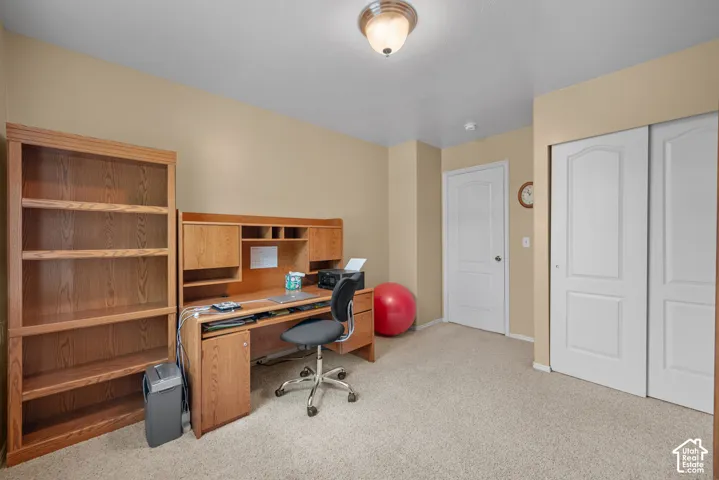 Neutral-toned room featuring carpeted flooring, a semi-flush mount light fixture, and a dual-panel sliding closet door