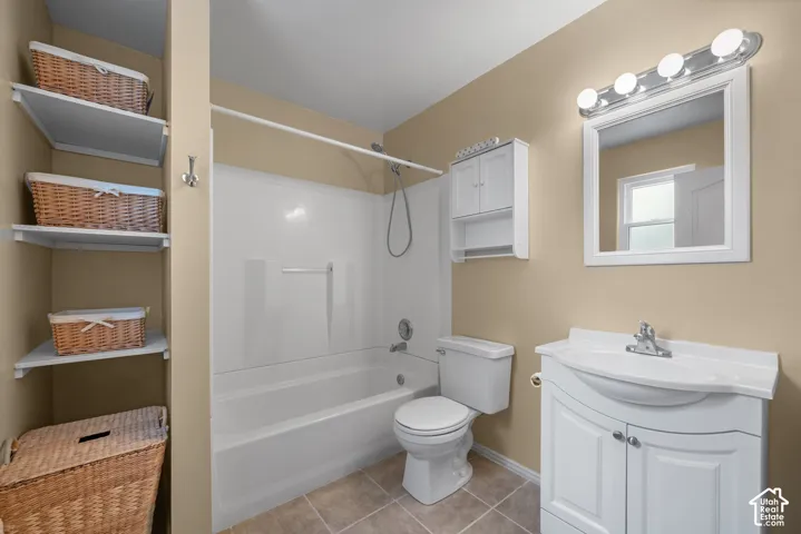 Bathroom featuring white vanity cabinetry, integrated sink, wall-mounted storage cabinet, four-light vanity fixture, and open shelving