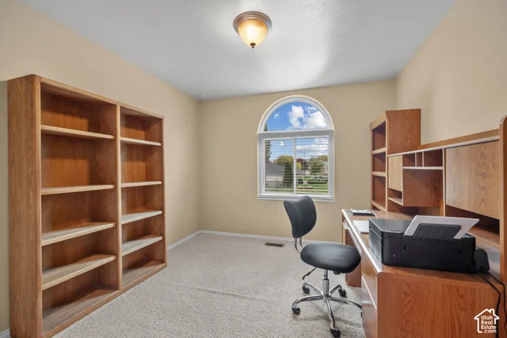 Room featuring built-in wood-finish cabinetry, an arched window, and a central ceiling-mounted light fixture