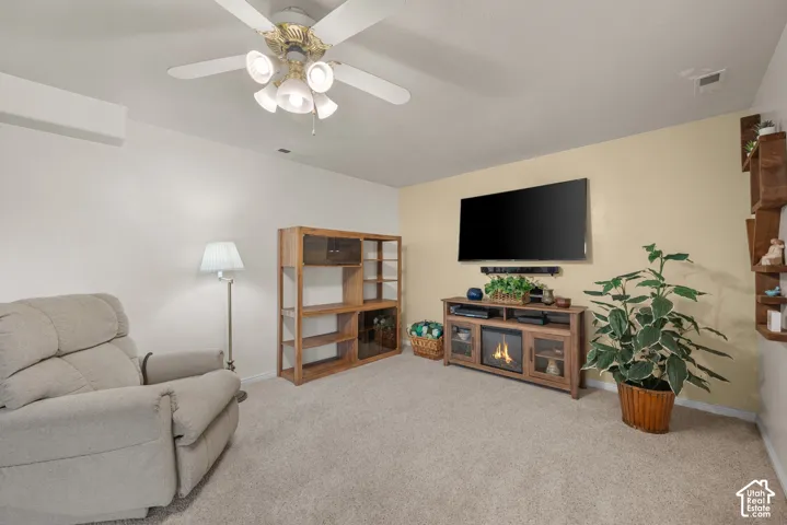 Wall-to-wall carpeting, ceiling fan with multi-light fixture, and neutral wall paint