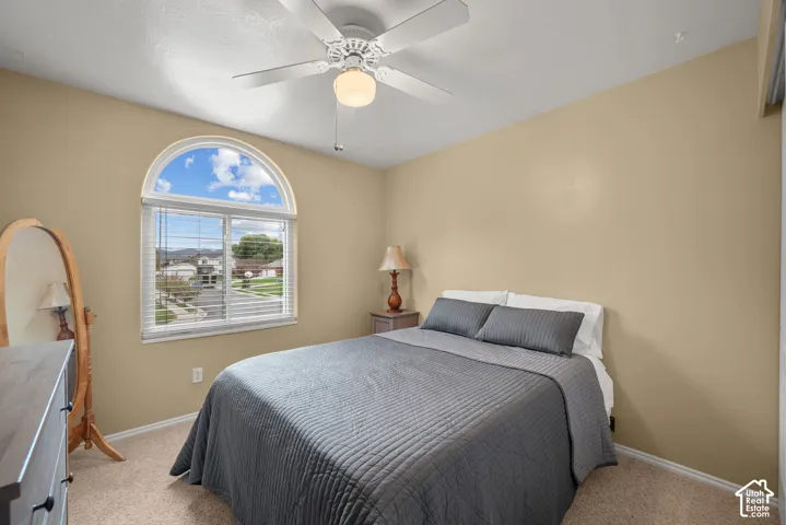 Room featuring arched window, neutral wall paint, and ceiling fan with integrated lighting