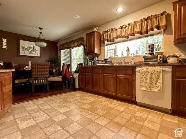 Kitchen featuring dark wood-finish cabinetry, stone-texture countertops, tile flooring, recessed lighting, and a dual-basin sink with a gooseneck faucet
