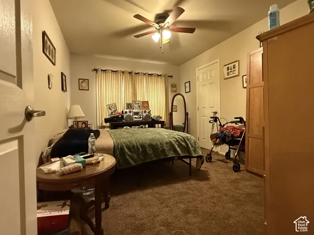 Room featuring neutral-toned carpeting, a multi-blade ceiling fan with integrated lighting, and a six-panel interior door