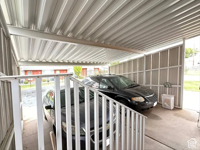 Covered carport featuring a metal corrugated roof, structural steel siding, and a concrete floor