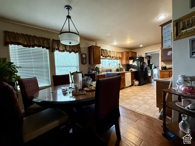 Kitchen featuring wood cabinetry, tiled flooring, built-in appliances, recessed lighting, and a pendant light fixture
