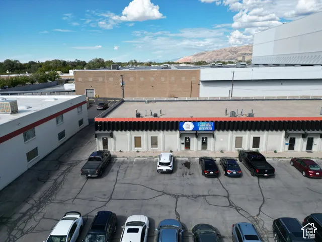 Commercial property exterior featuring a dedicated asphalt parking lot, masonry construction, decorative vertical facade accents, and roof-mounted HVAC units