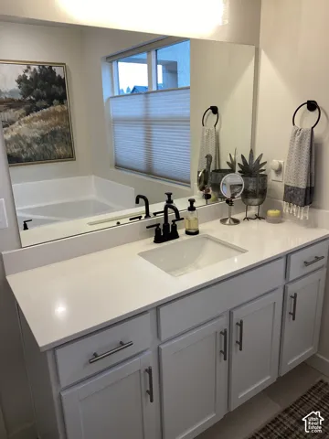 White vanity with shaker-style cabinetry, a built-in rectangular sink, and a white countertop