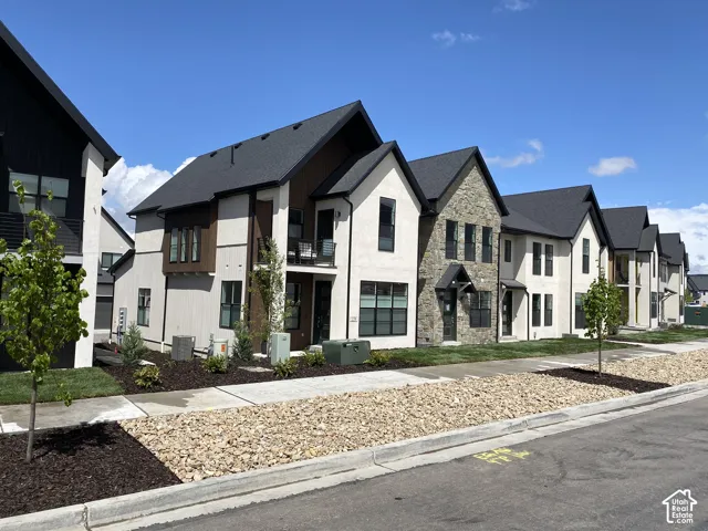 Contemporary architecture featuring dark shingle roofs, stucco exteriors, stone accents, and dark frame windows