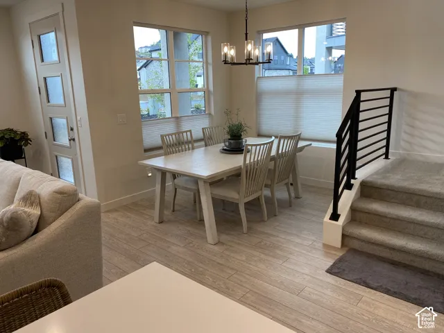 Dining area with wood-finish flooring, contemporary chandelier, and large windows