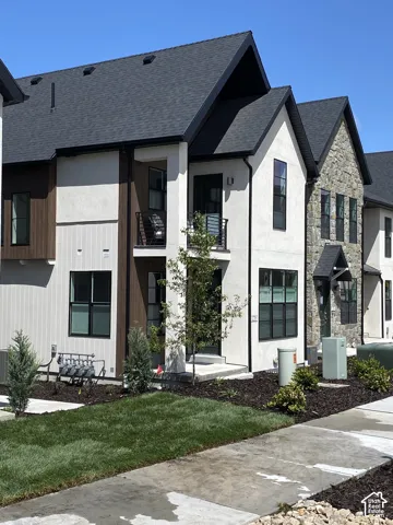Contemporary exterior featuring a combination of stucco, wood-finish siding, and stone accents