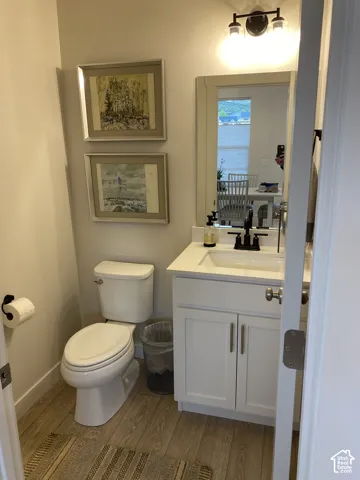 White vanity with shaker-style cabinetry, a built-in rectangular sink, and dark-finish hardware