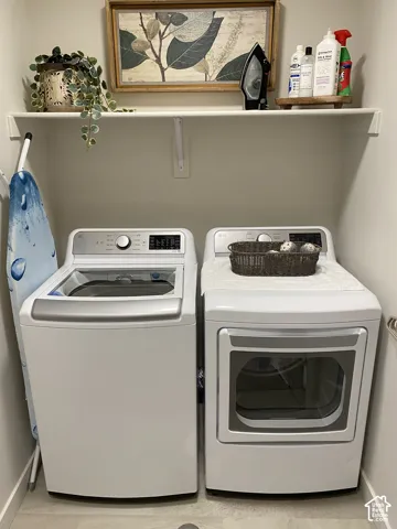 Dedicated laundry area featuring a built-in shelf and light-toned flooring