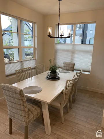 Recessed lighting and a multi-paneled window with cellular shades complement the wood-finish flooring