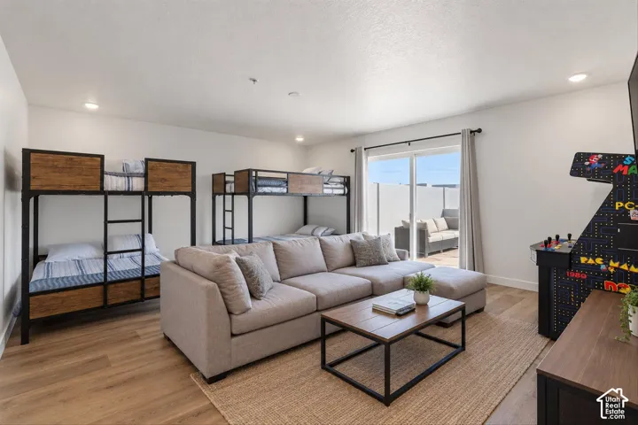 Neutral-toned interior featuring wood-finish flooring, recessed lighting, and sliding glass doors providing outdoor access