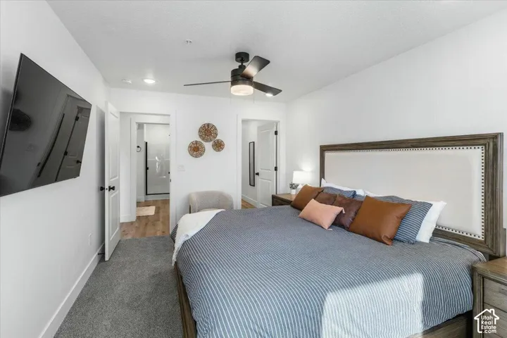 Neutral interior with wall-to-wall carpeting, multi-speed ceiling fan with integrated lighting, and white interior doors with matte black hardware