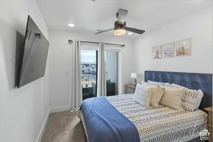 Room featuring neutral carpeting, recessed lighting, a modern ceiling fan, and a sliding glass door providing access to an outdoor space