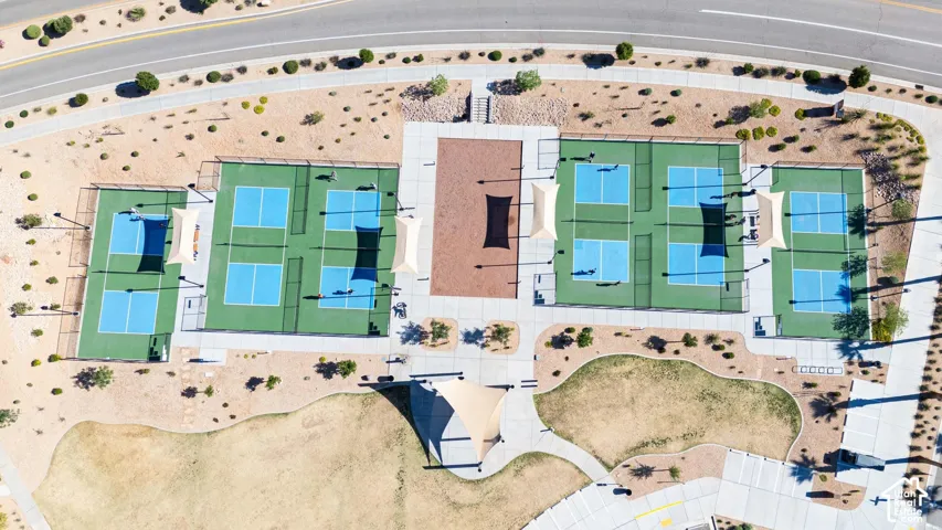 Community recreation area featuring multiple fenced sports courts, concrete walkways, integrated shade structures, and desert landscaping
