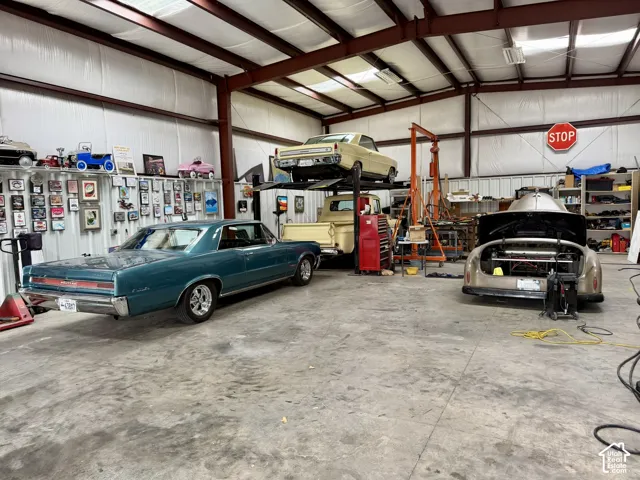 Expansive workshop featuring high-clearance ceilings, exposed steel framing, concrete flooring, and metal-panel wall construction