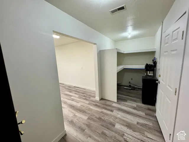 Wood-finish flooring, white panel door, and built-in shelving unit