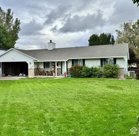 Ranch-style exterior featuring horizontal siding, masonry accents, an attached garage, and a covered entryway