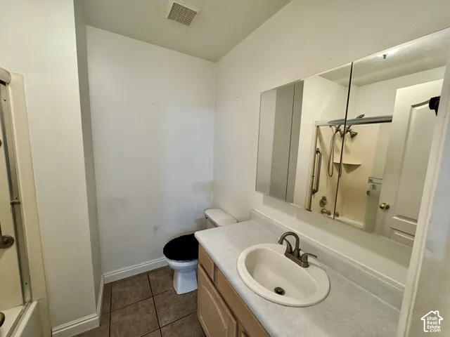 Bathroom featuring a vanity with an integrated basin, countertop with a matte-finish surface, tri-view medicine cabinet, tile flooring, and tub-shower combination
