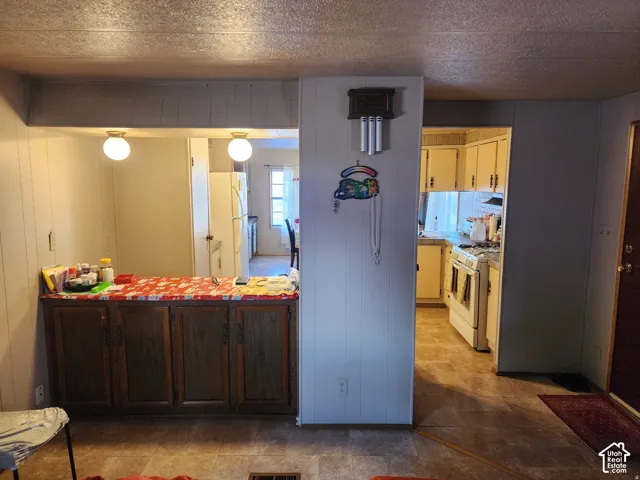 Kitchen area featuring wood-finish lower cabinetry, integrated ceiling globe lighting, and tile-finish flooring
