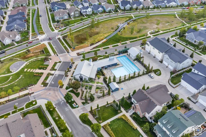 Community amenities featuring a rectangular swimming pool, landscaped garden area, paved parking lot, and nearby pedestrian pathways