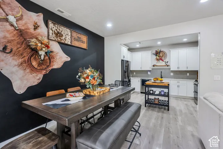 Kitchen featuring white shaker-style cabinetry, matte black hardware, recessed lighting, and wood-finish flooring