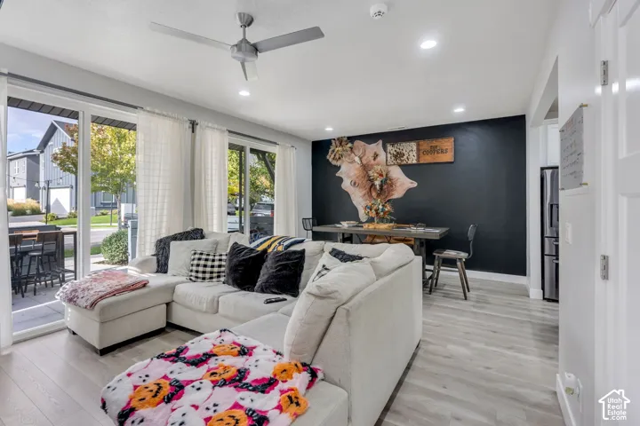 Open floor plan featuring wood-finish flooring, recessed lighting, a brushed-metal ceiling fan, and sliding glass doors with access to an exterior patio