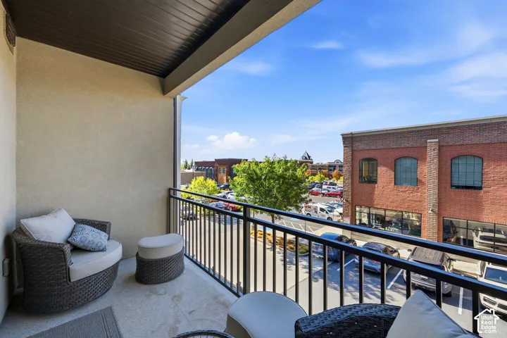 Covered balcony featuring concrete flooring, black metal railing, and neutral exterior wall finish