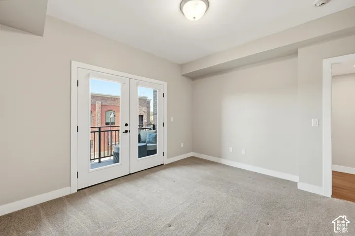 Room featuring neutral wall tones, neutral carpeting, flush-mount ceiling lighting, and double glass-pane doors