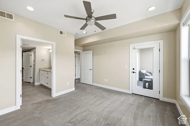 Interior space featuring high ceilings, wall-to-wall carpeting, recessed lighting, a modern ceiling fan, and a door with an inset glass panel