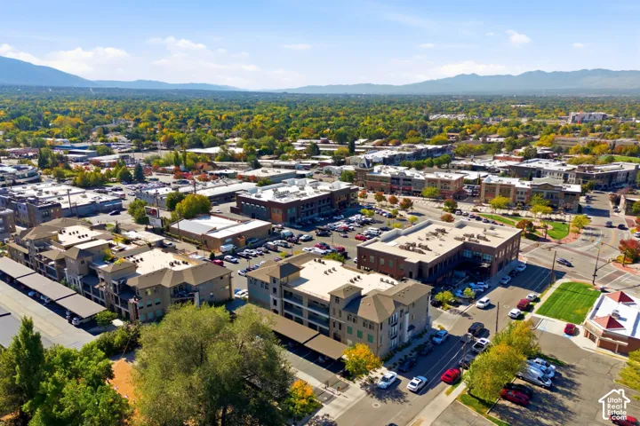 Aerial perspective of multi-story mixed-use architecture featuring covered parking structures and mountain backdrops