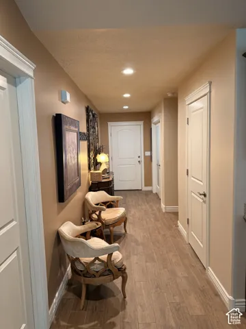 Interior hallway featuring wood-finish flooring, recessed lighting, and multi-panel interior doors