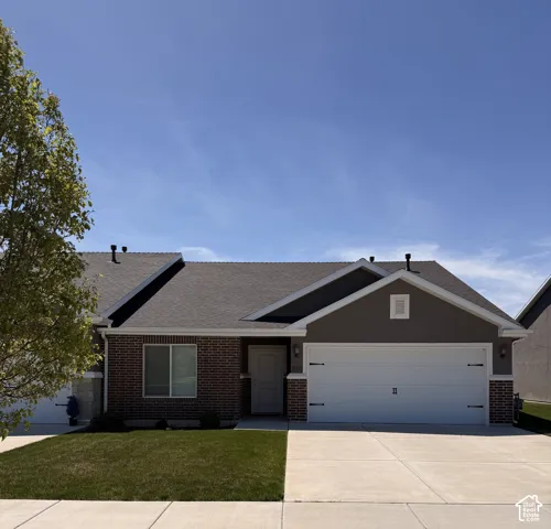 Single-story exterior featuring a brick and composite siding facade, shingle roof, two-car garage with carriage-style hardware, and a concrete driveway