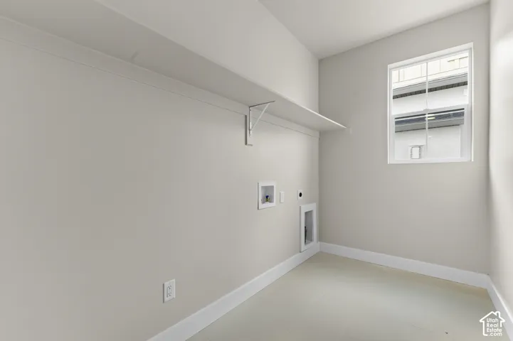 Utility space featuring tile flooring, neutral wall paint, a built-in wall shelf, and a multi-pane window