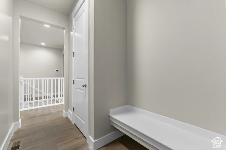 Built-in white bench seating, wood-finish flooring, and white paneled doors featuring satin nickel hardware