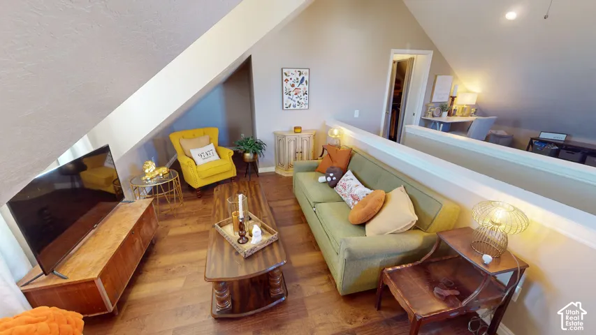 Vaulted ceiling, wood-finish flooring, and pony wall partition