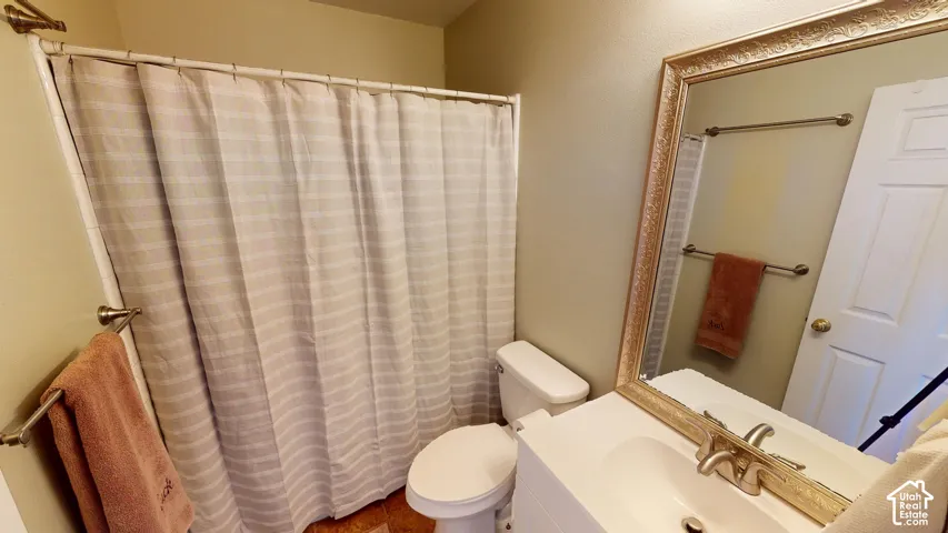Bathroom featuring a vanity with an integrated basin, wide-frame wall mirror, and dual brushed-metal towel bars