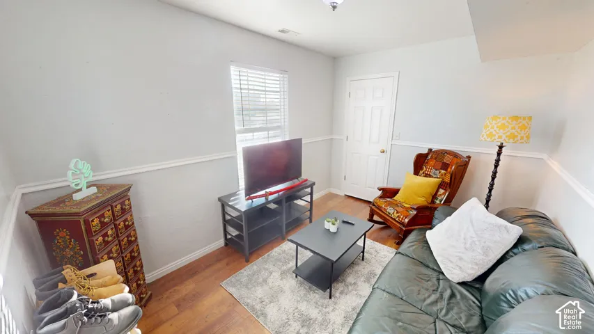 Wood-finish flooring, chair rail molding, and window with horizontal blinds
