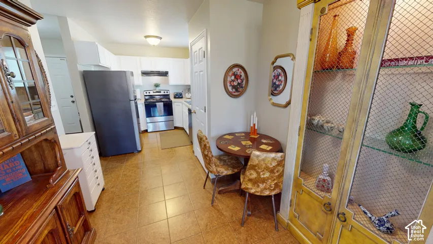 Kitchen featuring stainless steel appliances, white cabinetry, and ceramic tile flooring