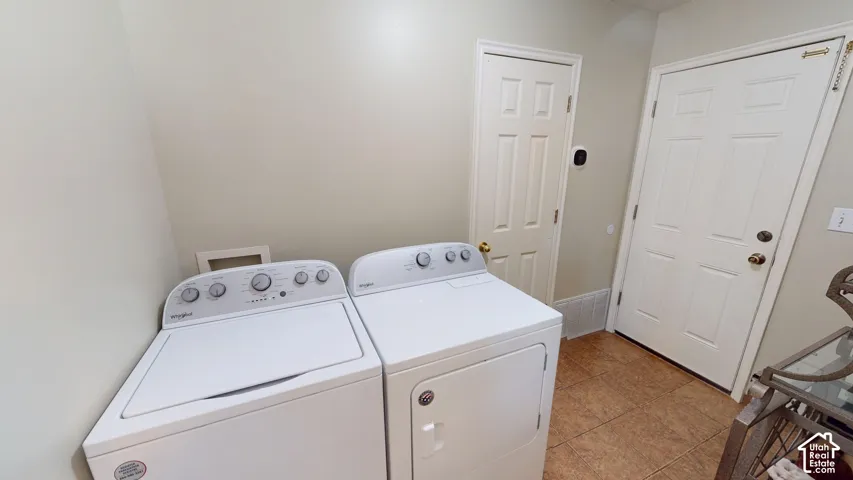 Utility area featuring tile flooring, six-panel interior doors, and built-in laundry hookups