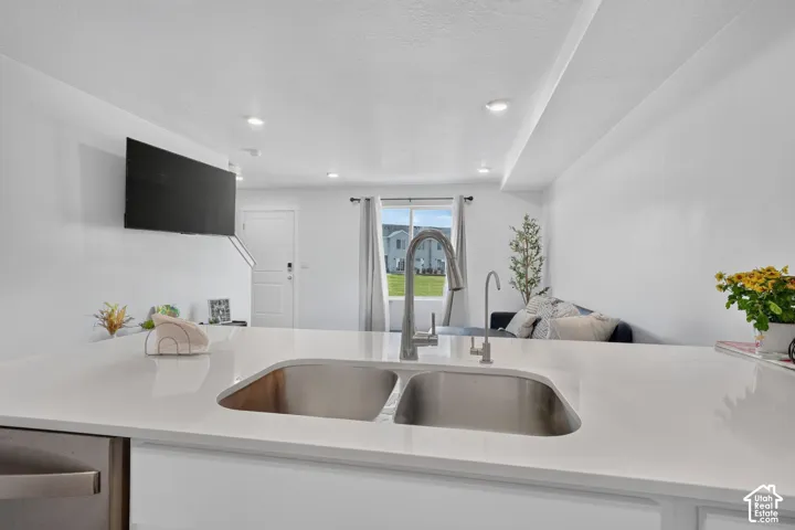 Kitchen island with a dual-basin stainless steel sink and gooseneck faucet
