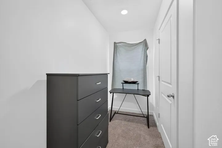 Recessed ceiling lighting, white walls, and carpet flooring